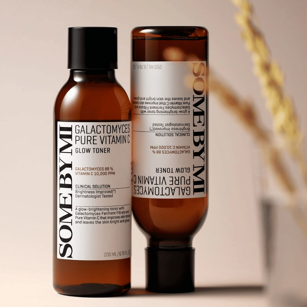 Imagem de SOME BY MI Galactomyces Pure Vitamin C Glow Toner. Os frascos têm um design elegante com tons marrons e tampa preta. O produto contém 88% de galactomyces e 10.000 ppm de vitamina C, o que promete melhorar o brilho da pele e dar um tom de pele mais fresco.