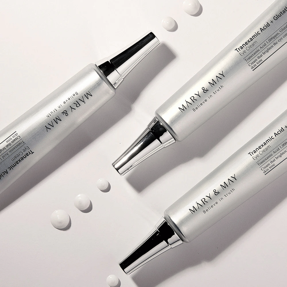 Imagem estilizada do produto Mary&May Tranexamic Acid + Glutathione Eye Cream mostrando a consistência do creme e foco no cuidado iluminador dos olhos.