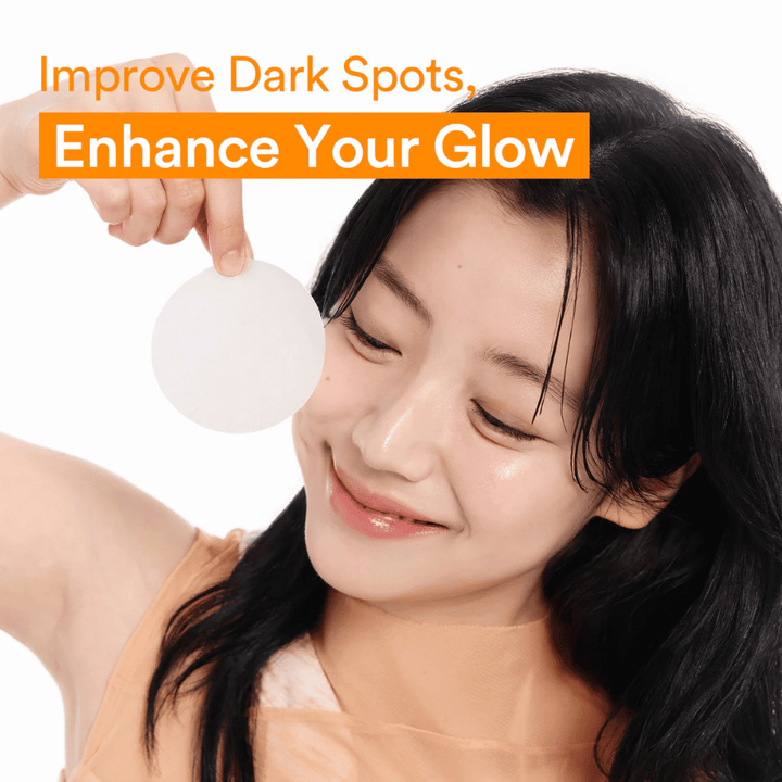 Mulher segura uma toner pad iluminadora para reduzir manchas escuras e proporcionar uma pele mais luminosa.