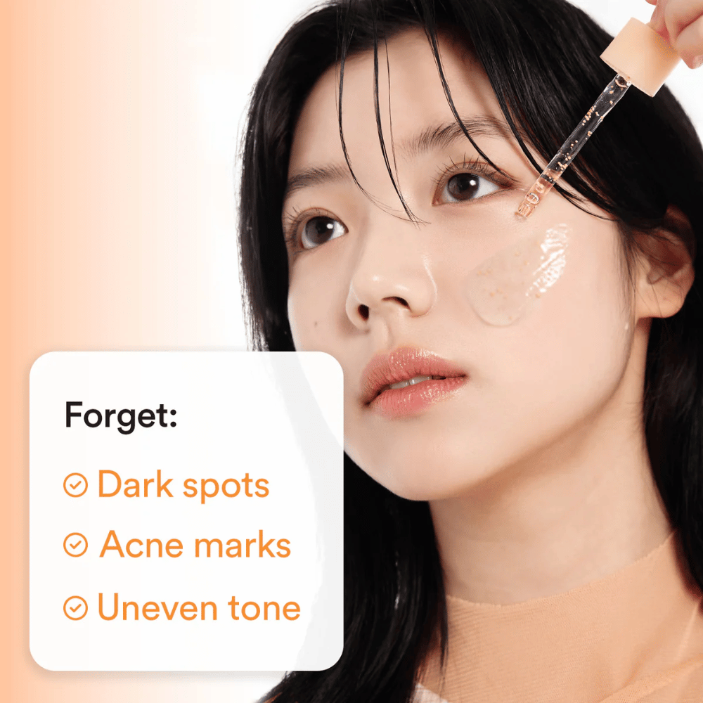 Mulher aplica sérum com conta-gotas na bochecha. Texto na imagem lista Vantagens: "Esqueça: Manchas escuras, Marcas de acne, Tom irregular".