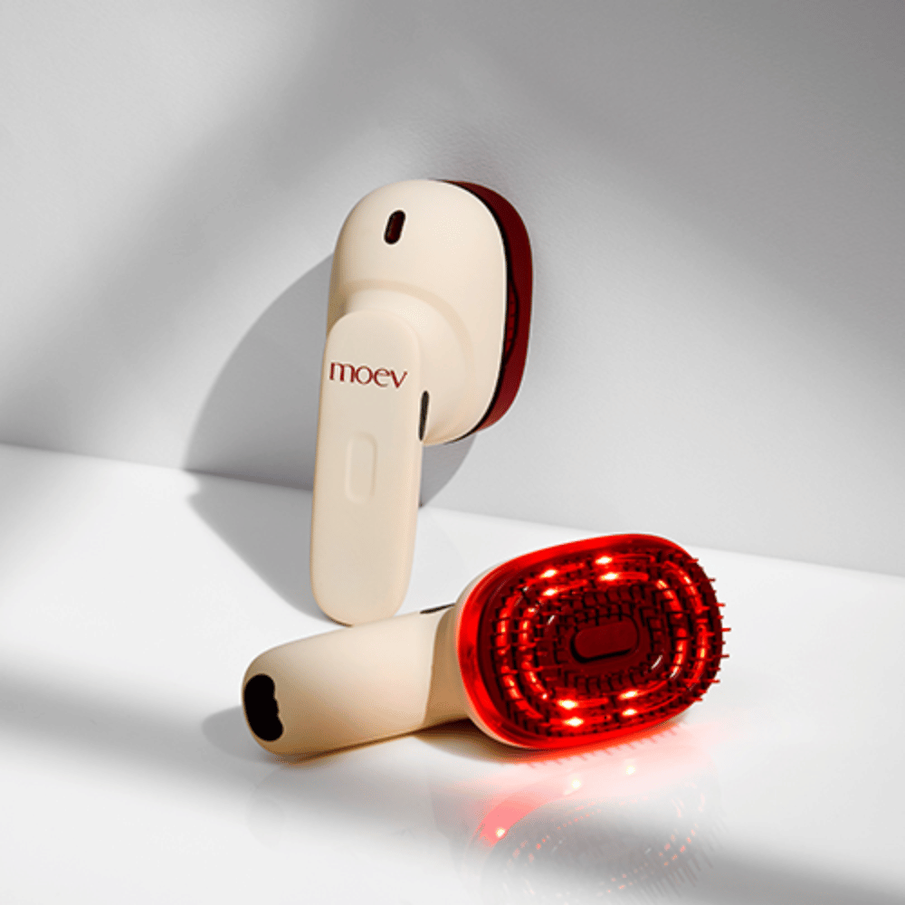 Dois MOEV Hair Steamer Pro em fundo branco. Um mostra luzes LED vermelhas ativadas que estimulam o couro cabeludo e melhoram o crescimento do cabelo.