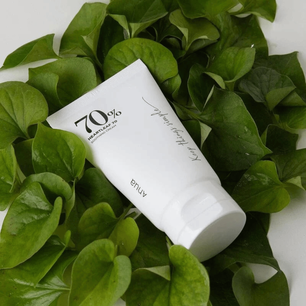 Um tubo de Heartleaf 70% Soothing Cream repousa sobre uma cama de folhas verdes.