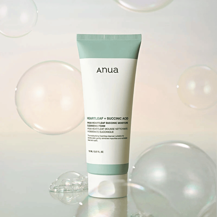 Imagem de produto de Anua Heartleaf + Succinic Acid Moisture Cleansing Foam rodeado por bolhas transparentes. A imagem reforça a sensação de limpeza suave, frescura e uma espuma leve.