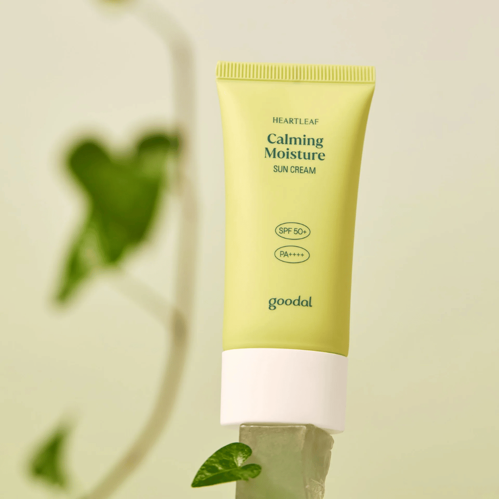 Goodal Heartleaf Calming Moisture Sun Cream SPF50+ PA++++ colocado em uma placa de vidro com planta verde ao fundo – um protetor solar calmante para pele sensível.