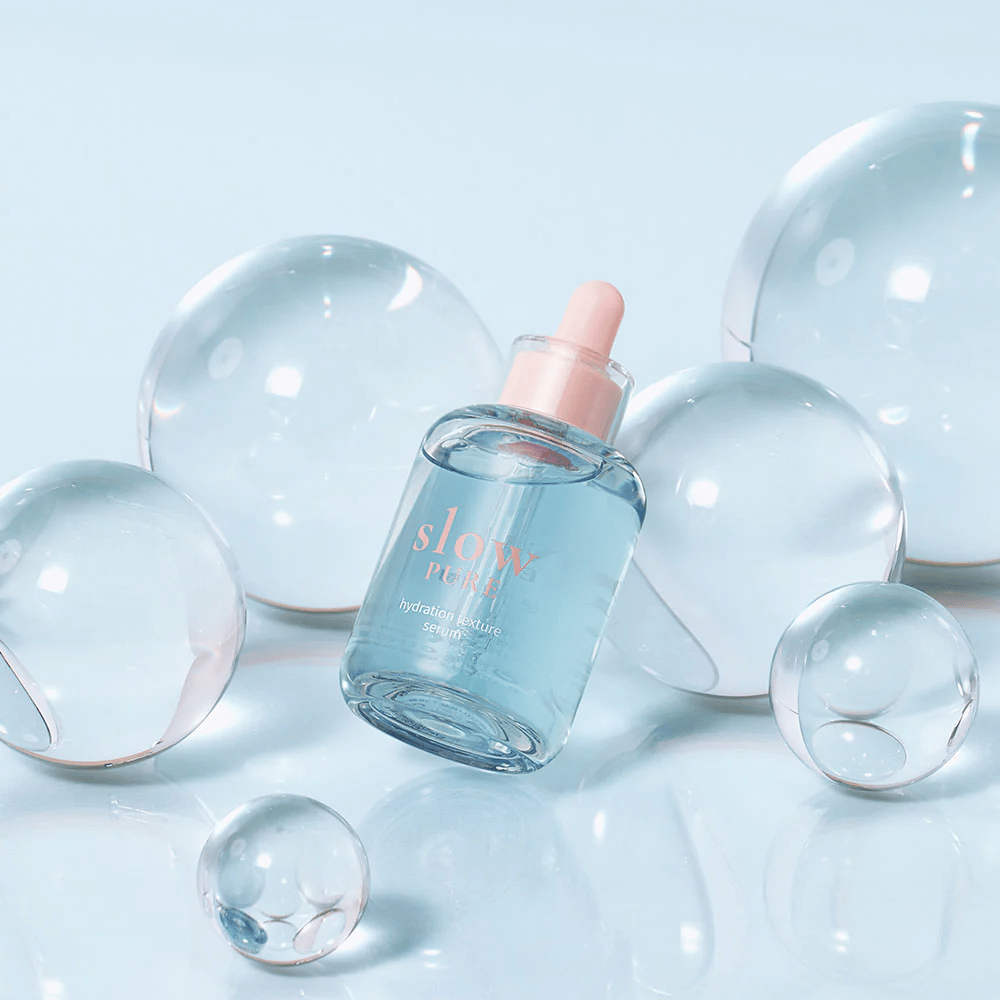 Slow Pure Hydration Texture Serum colocada entre bolhas transparentes, símbolo de hidratação intensa.
