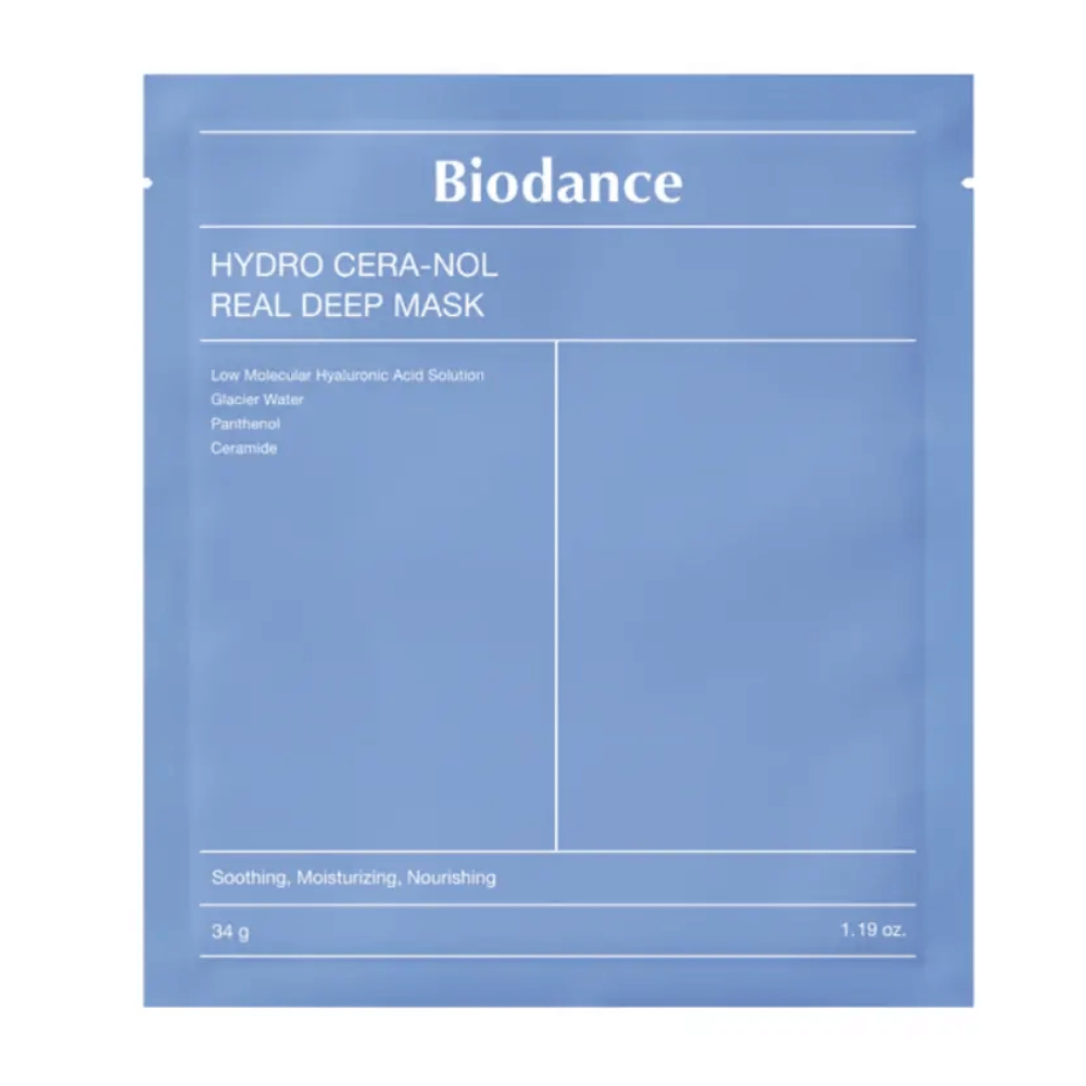 A embalagem mostra "Biodance Hydro Cera-Nol Real Deep Mask". É uma máscara facial calmante, hidratante e nutritiva contendo ácido hialurônico de baixo peso molecular, água glaciar, pantenol e ceramidas. O design é simples em um tom de azul calmante.