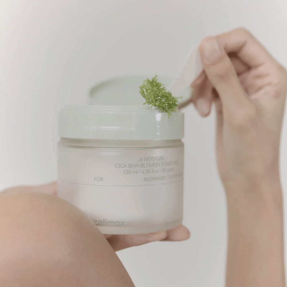 Celimax Ji Woo Gae Cica BHA Blemish Toner Pad com extrato de centella é mostrado em uso – esfoliação suave para pele clara.