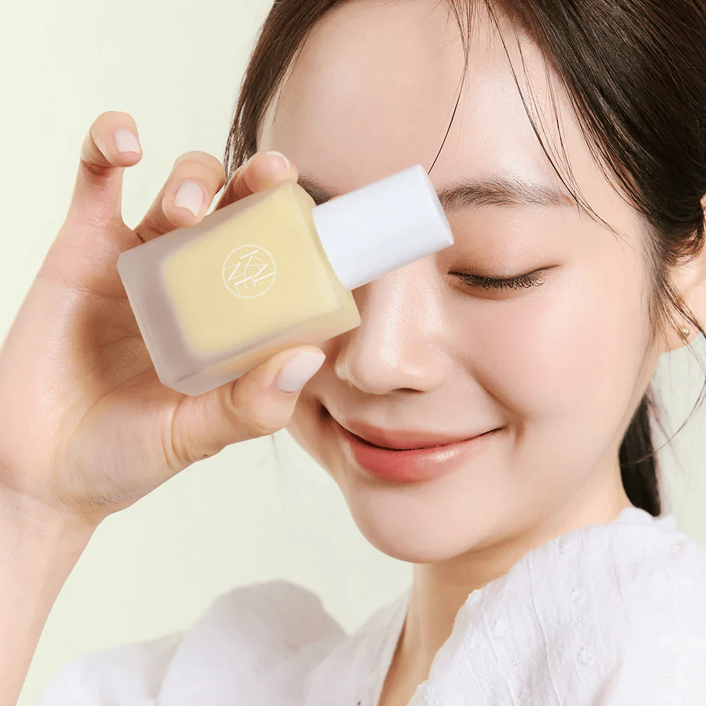 Uma mulher segura um frasco KAINE Vita Drop Serum de 30ml.