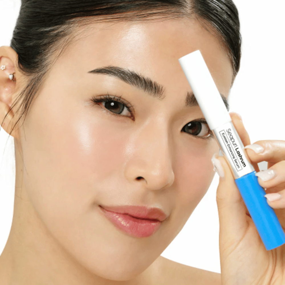 Mulher segurando Seapuri Lashrum Eyelash Enhancing Serum. Um sérum para cílios que cuida, fortalece e define os cílios.