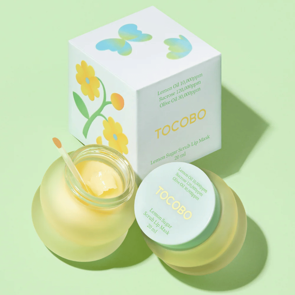 Tocobo Lemon Sugar Scrub Lip Mask junto com sua embalagem com design floral em um fundo verde claro.