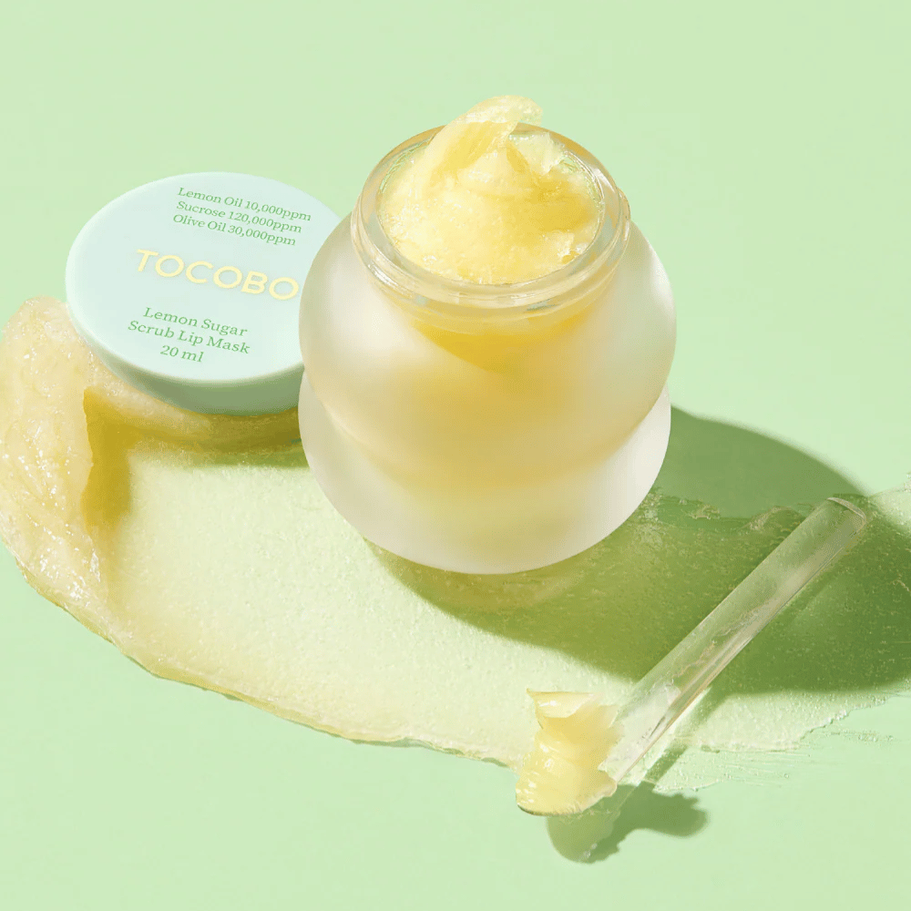 Frasco aberto com Tocobo Lemon Sugar Scrub Lip Mask em um fundo verde, com o conteúdo claramente visível.