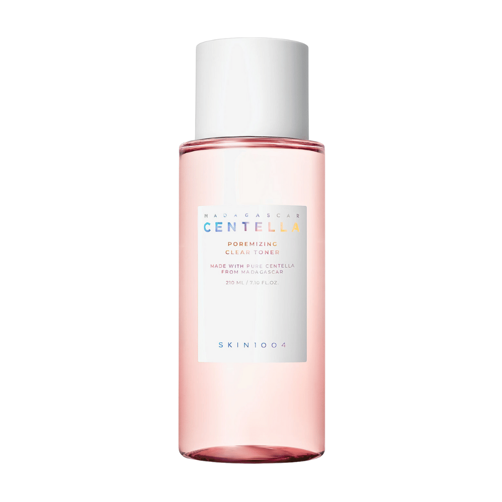 Uma garrafa de Madagascar Centella Poremizing Clear Toner, que é transparente com um tom rosa. O produto tem uma tampa branca e rótulo com o texto "Poremizing Clear Toner" e "Made with Pure Centella from Madagascar." A garrafa contém 210 ml e proporciona uma sensação de frescura e cuidado da pele.