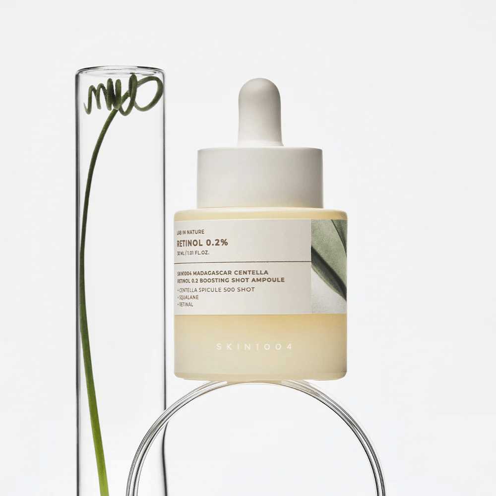 SKIN1004 Madagascar Centella Retinol 0.2 Boosting Shot Ampoule em imagem de estilo de vida com elementos botânicos – soro facial que apoia a renovação da pele e fortalece a barreira cutânea.
