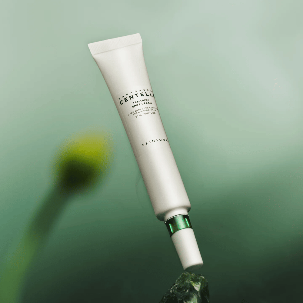 SKIN1004 Madagascar Centella Tea-Trica Spot Cream flutuando contra um fundo verde – tratamento eficaz para acne treatment para pele propensa a acne com centella de Madagascar.