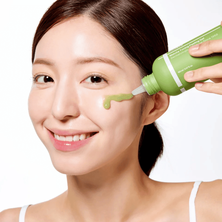 Pessoa aplicando Centellian24 Madeca Matcha Toning Peeling Gel – esfoliação suave que ajuda a remover células mortas da pele e a deixar a pele mais macia e radiante.