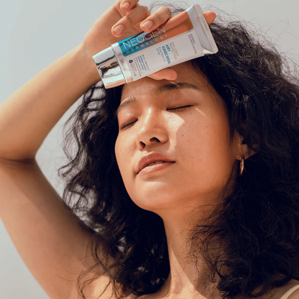 Neogen Dermalogy Day-Light Protection Airy Sunscreen SPF50 50ml – creme solar leve com proteção UV de amplo espectro, demonstrado em uso sob luz solar.
