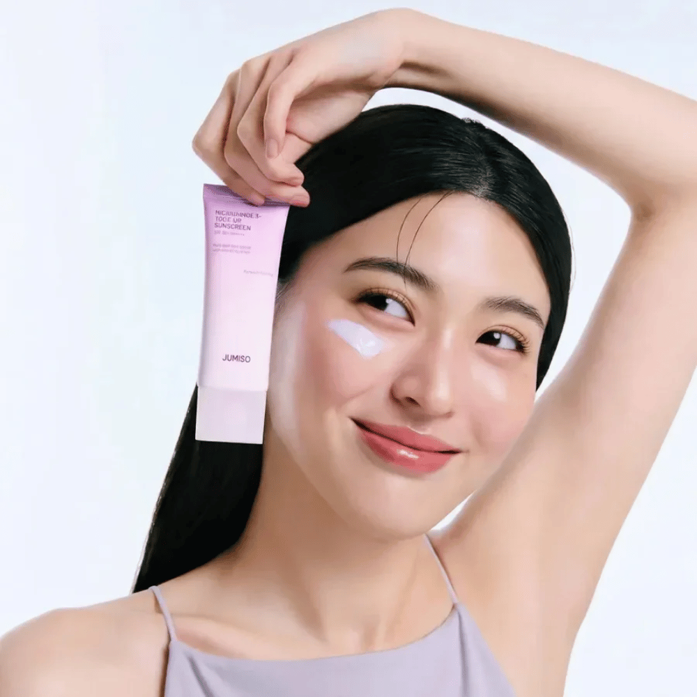 A modelo segura JUMISO Niacinamide 3+ Tone-Up Sunscreen SPF50+ PA++++ – protetor solar com niacinamida que uniformiza o tom de pele e protege a pele.