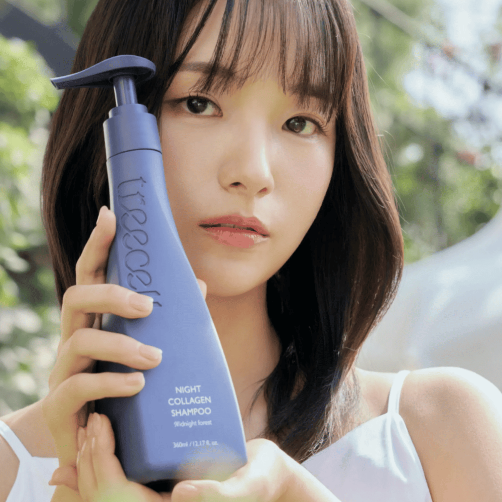 Mulher segura Treecell Night Collagen Shampoo Midnight Forest num ambiente natural. A imagem transmite cabelo saudável, brilho e uma sensação premium, com foco no cuidado do cabelo e do couro cabeludo.