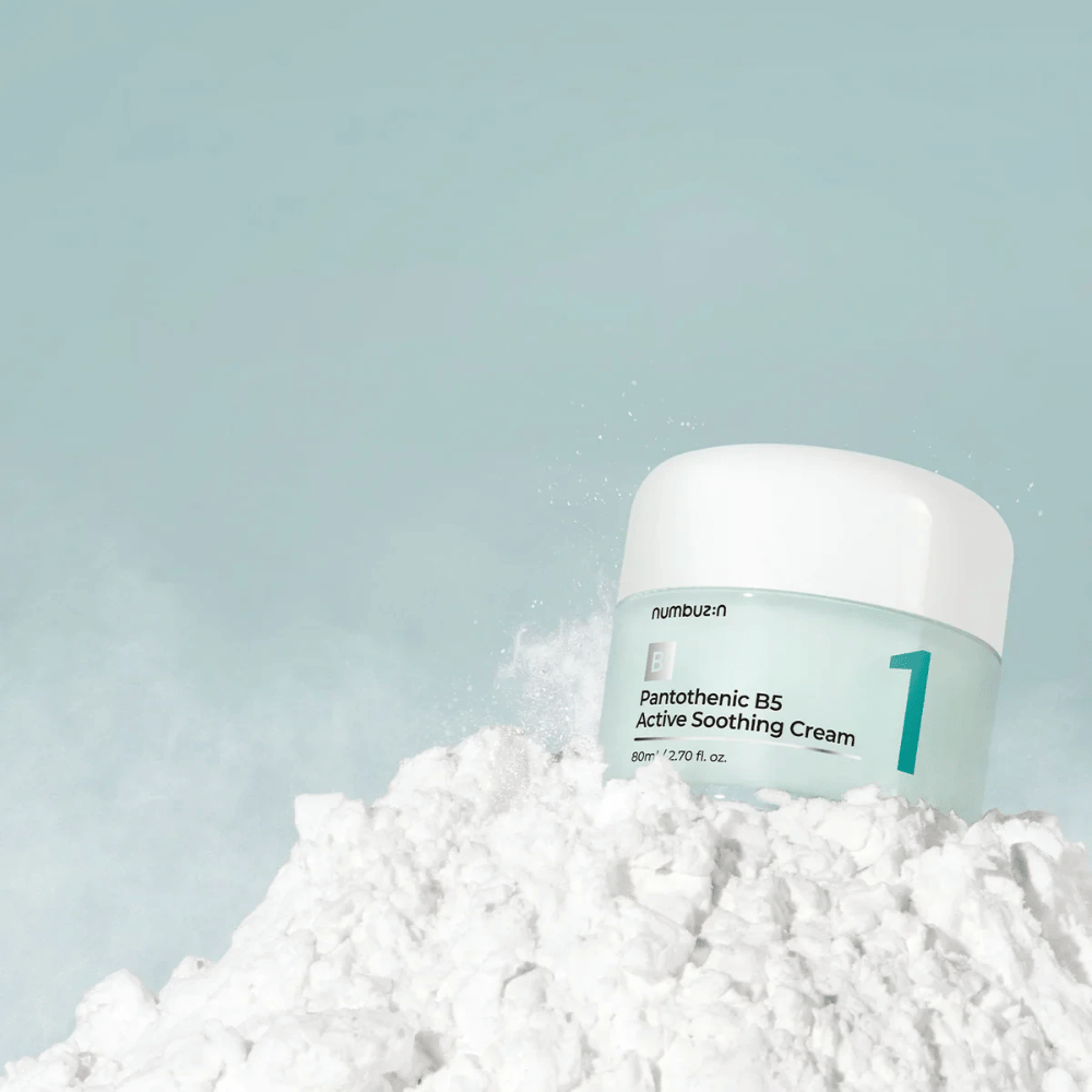 Numbuzin No.1 Pantothenic B5 Active Soothing Cream 80 ml em pote verde-claro com tampa branca, colocado sobre uma pilha de pó branco contra um fundo claro.
