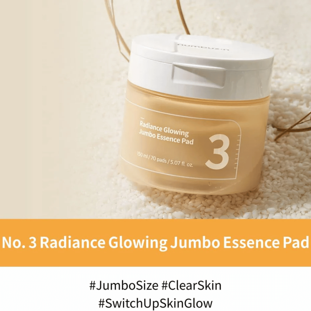 Frasco com numbuzin No. 3 Radiance Glowing Jumbo Essence Pad colocado sobre arroz, texto na imagem destaca o tamanho jumbo e o brilho da pele.
