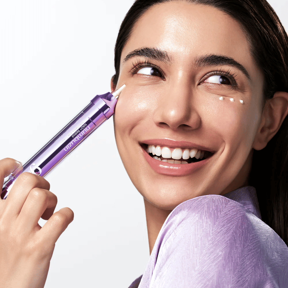 Modelo aplicando No.9 NAD+ Retinol Volumetox Eye Cream ao redor dos olhos com aplicador de precisão, para cuidado direcionado contra olheiras e linhas finas.