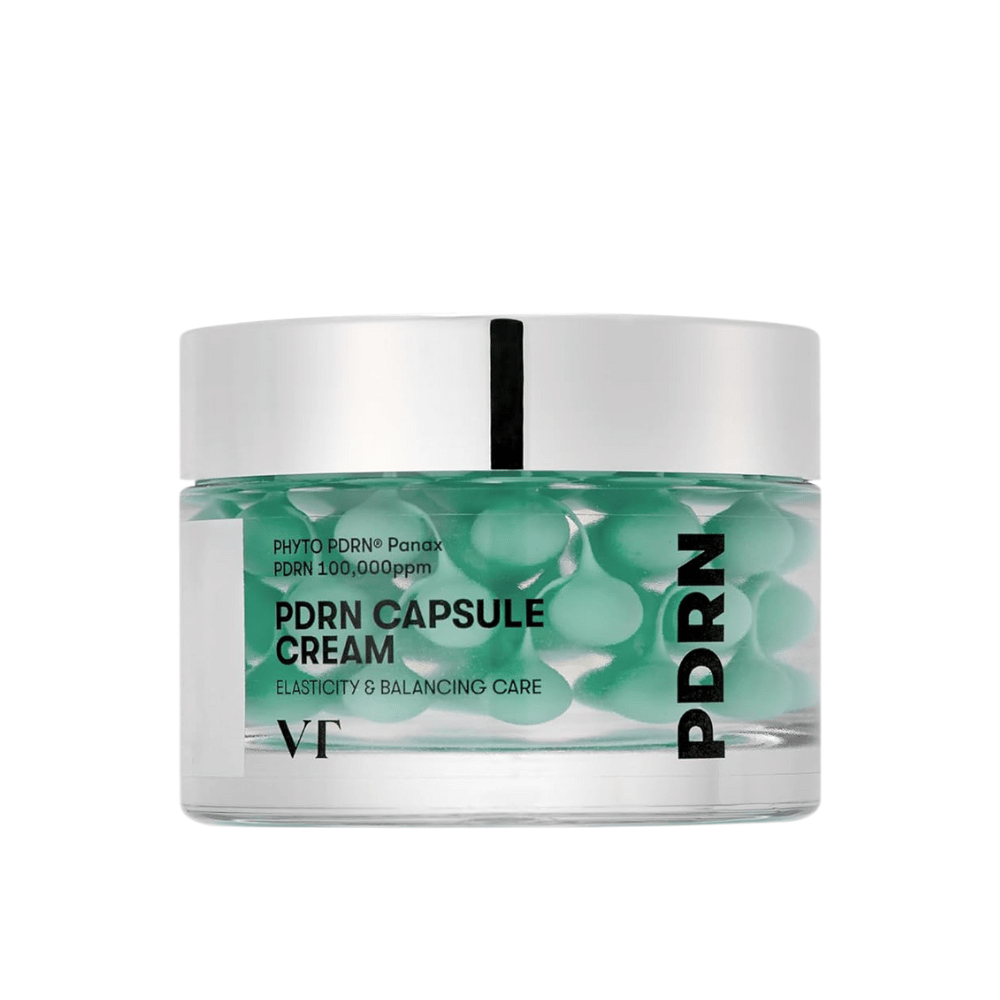 VT PDRN Capsule Cream em um frasco transparente com tampa prateada. O conteúdo consiste em cápsulas verdes em um gel claro, e o rótulo indica que o creme é destinado à elasticidade e cuidado equilibrante da pele.