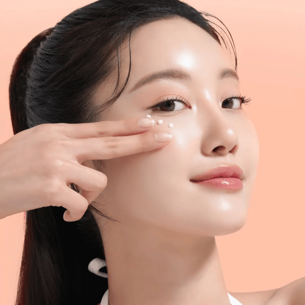 Pessoa aplica Mixsoon PDRN Collagen Eye Serum sob os olhos. O sérum ilumina, reduz o inchaço e fortalece a firmeza da pele.