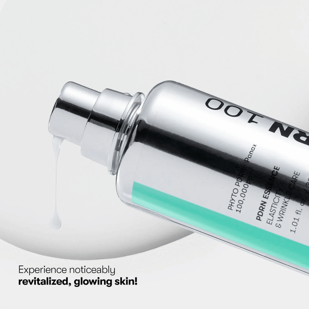 Close-up de um frasco de bomba prateado com VT PDRN Essence 100. Uma essência branca escorre do bocal, e o texto na imagem diz: "Experimente uma pele visivelmente revitalizada e radiante!"