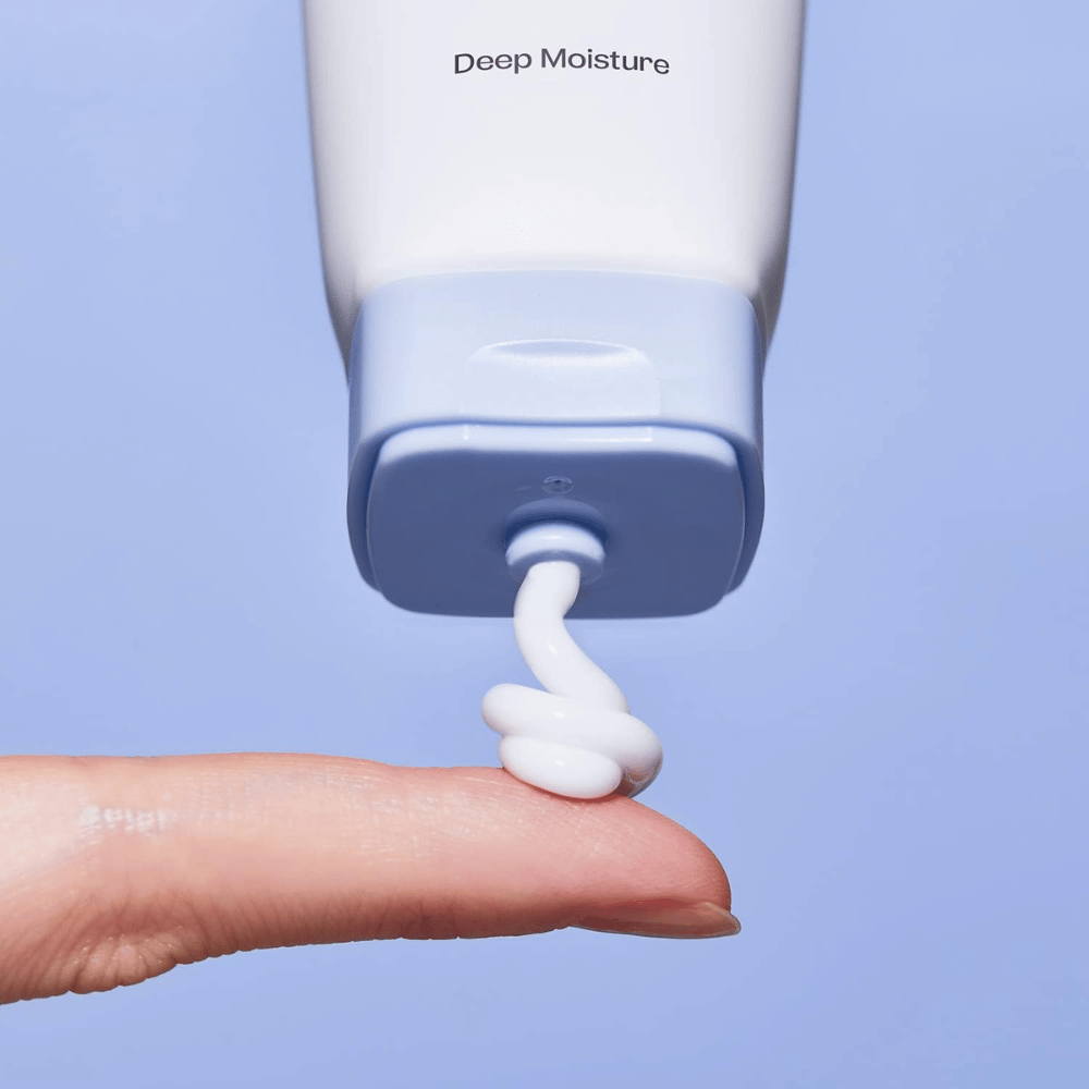 1. Ma:nyo Panthetoin Cream – grande plano de creme facial hidratante branco a ser aplicado de um tubo azul-claro num dedo
