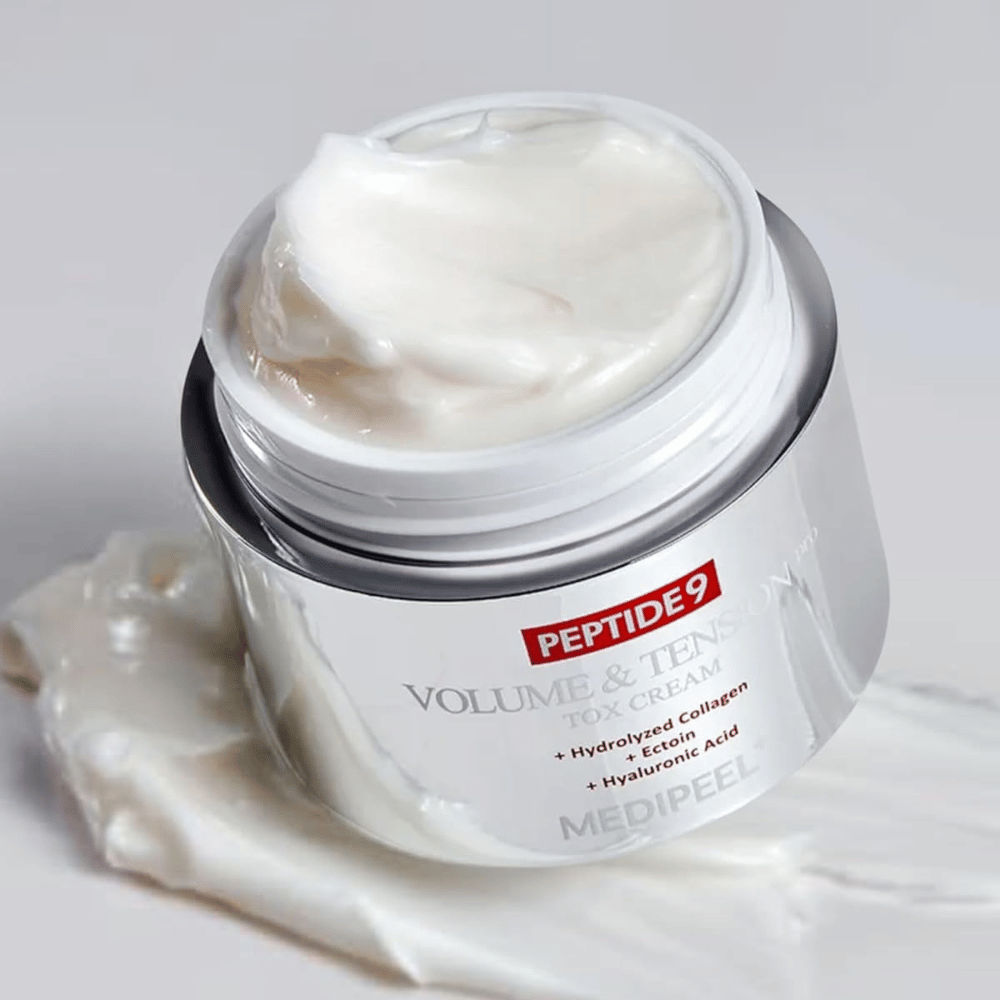 Close-up de MEDI-PEEL Peptide 9 Volume & Tension Tox Cream. O creme rico contém colágeno hidrolisado, ectoína e ácido hialurônico para uma pele mais firme e hidratada.