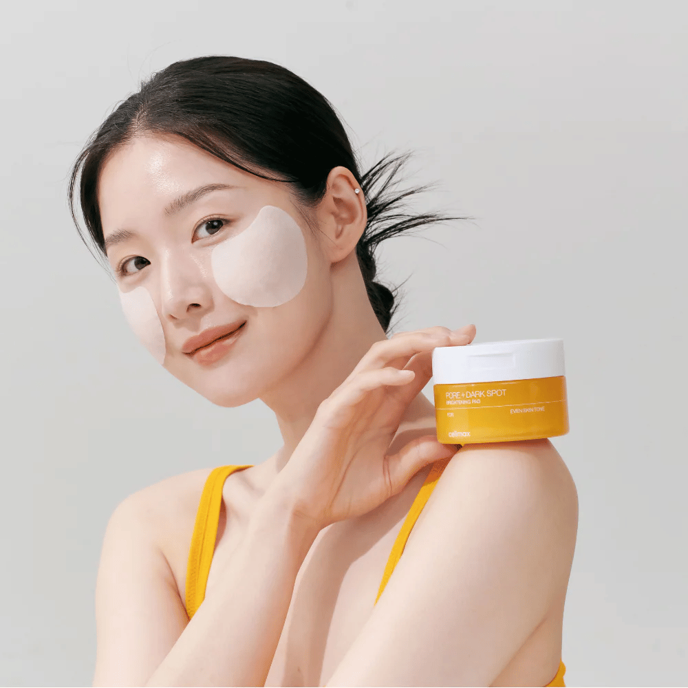 Mulher aplica Celimax Pore + Dark Spot Brightening Pad – almofadas coreanas que uniformizam o tom da pele e reduzem poros e manchas de pigmentação.