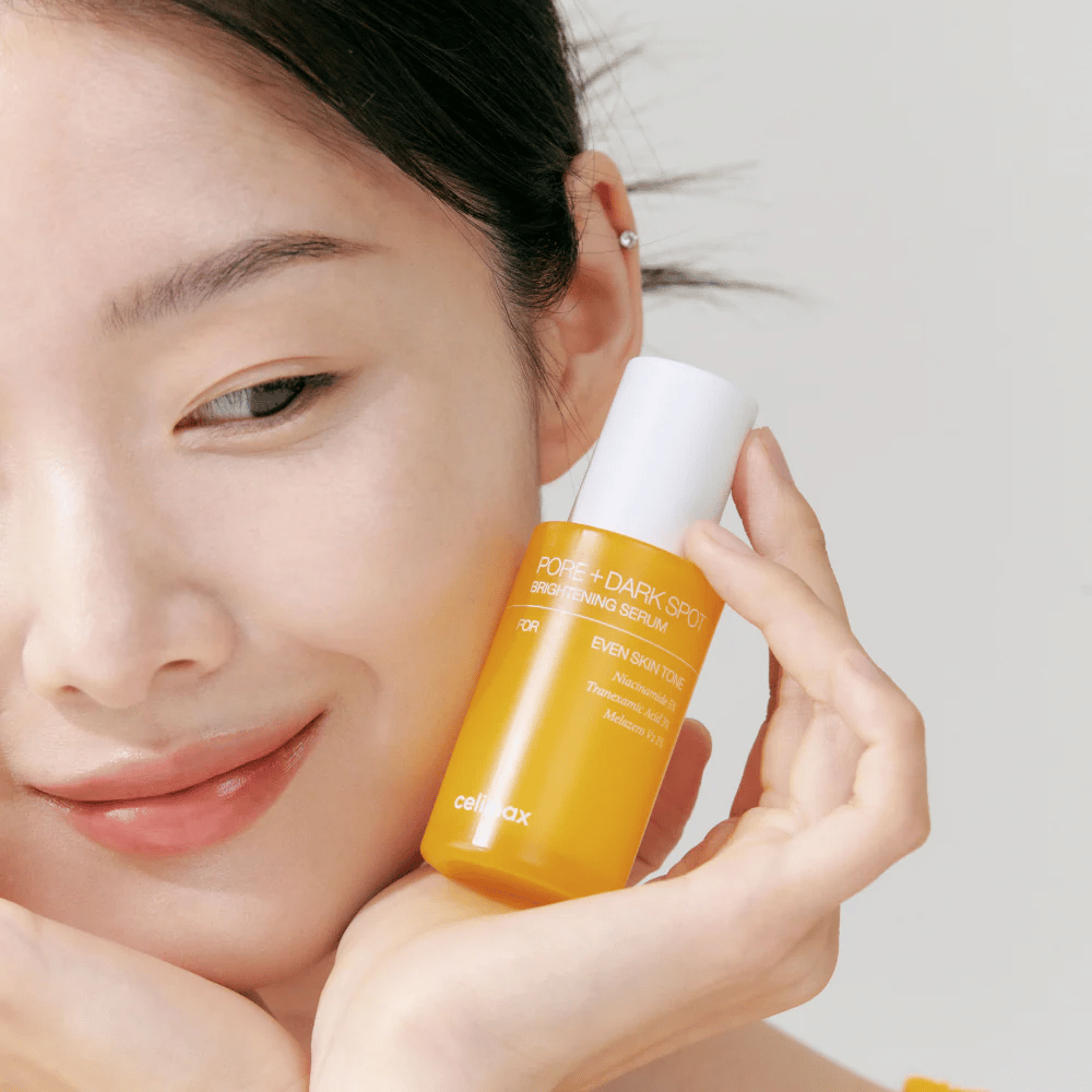Modelo segura Celimax Pore + Dark Spot Brightening Serum perto do rosto, mostra pele radiante.