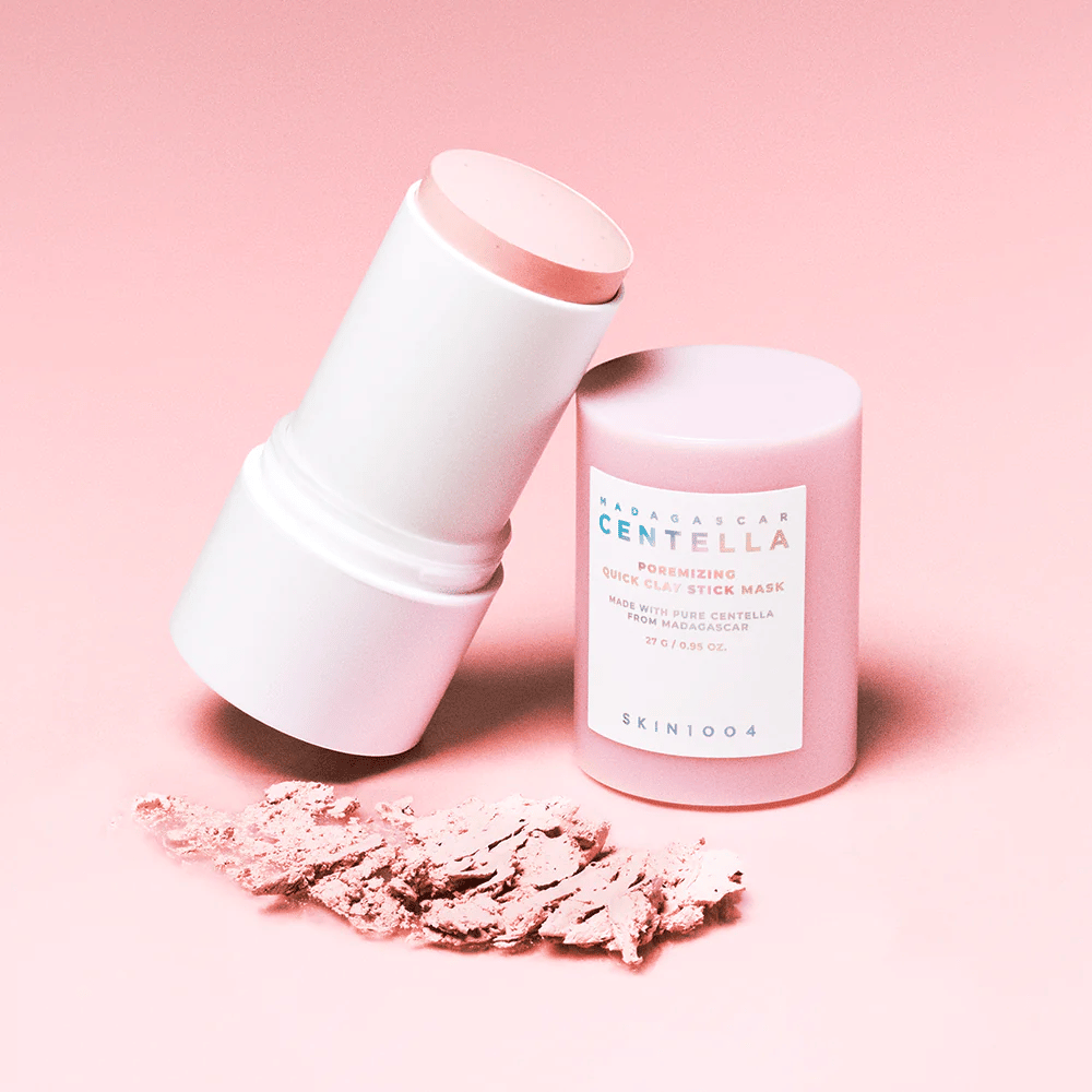SKIN1004 Madagascar Centella Poremizing Quick Clay Stick Mask em uma embalagem rosa. Máscara de argila prática em formato stick para limpar e minimizar poros.
