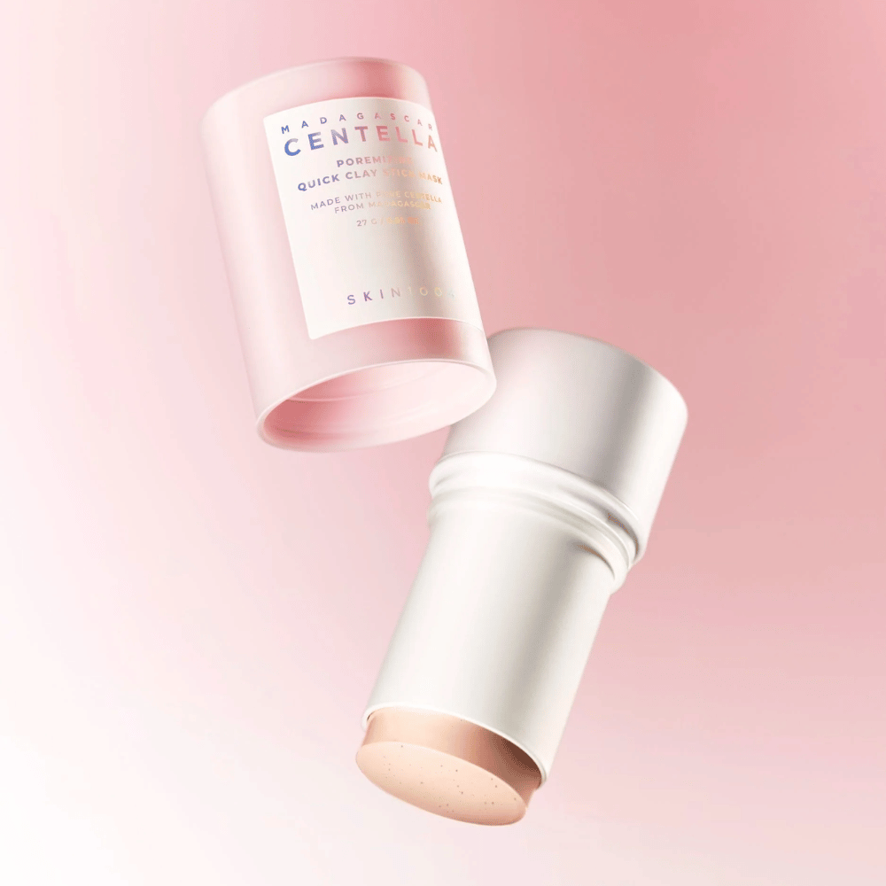 SKIN1004 Madagascar Centella Poremizing Quick Clay Stick Mask em um design elegante rosa e branco. Formato stick prático para fácil aplicação e limpeza profunda.