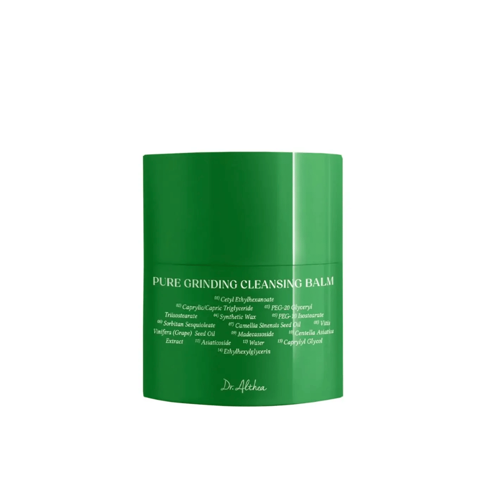 A imagem mostra um pote verde com "Pure Grinding Cleansing Balm" de Dr. Althea. A embalagem é simples e elegante, com texto branco que lista ingredientes chave como óleo de semente de uva, extrato de centella asiatica e óleo de semente de camélia. O design transmite uma sensação de cuidado com a pele natural e eficaz.