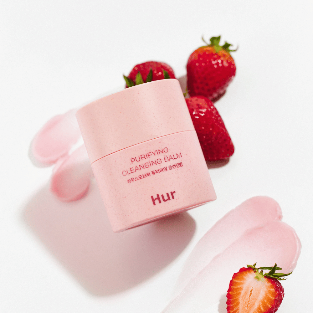 Como Purifying Cleansing Balm colocado com morangos frescos. Bálsamo de limpeza que proporciona uma pele macia e é adequado para a limpeza facial diária.