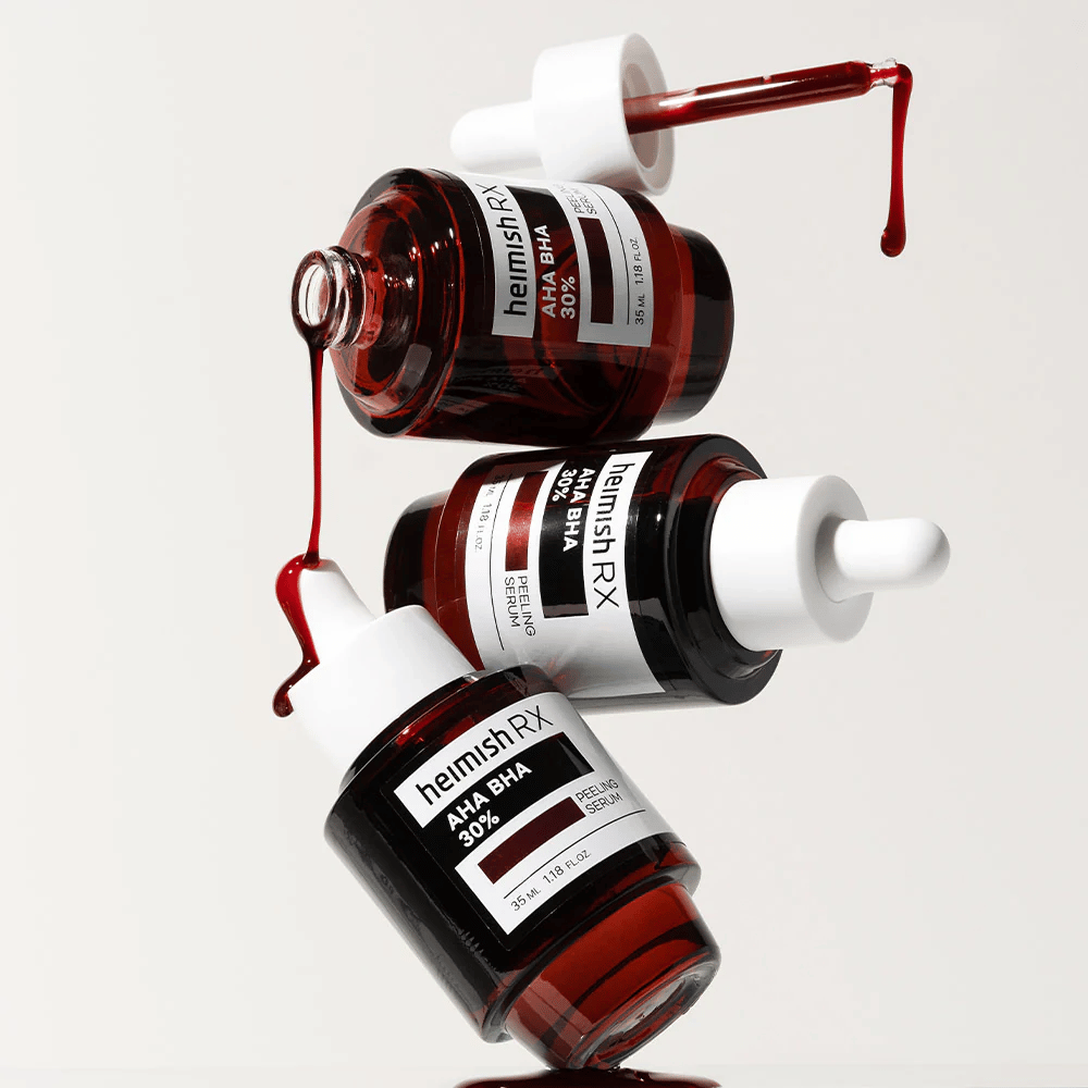 Três frascos de Heimish RX AHA BHA 30% Peeling Serum em uma composição dinâmica, com soro vermelho pingando das pipetas.