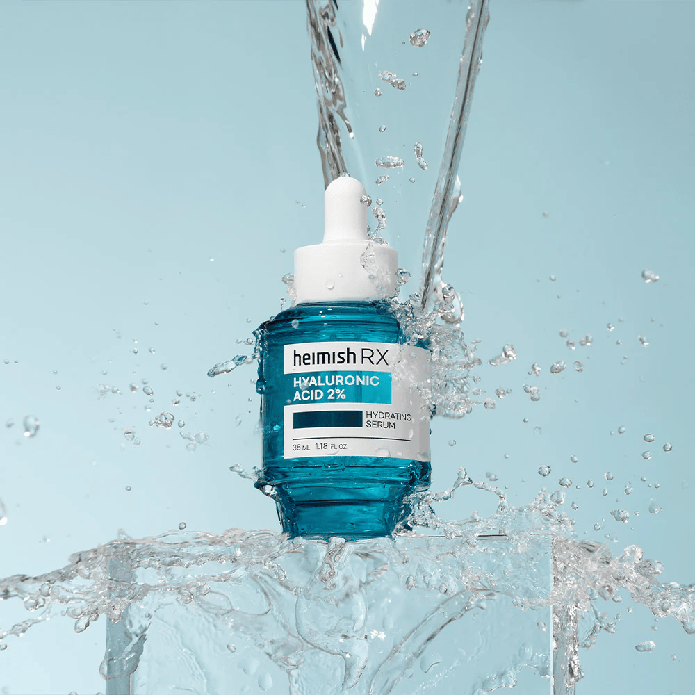 Heimish RX Ácido Hialurônico 2% Sérum Hidratante colocado sobre uma superfície semelhante a gelo com água espirrando ao redor, simbolizando hidratação intensa e frescor.