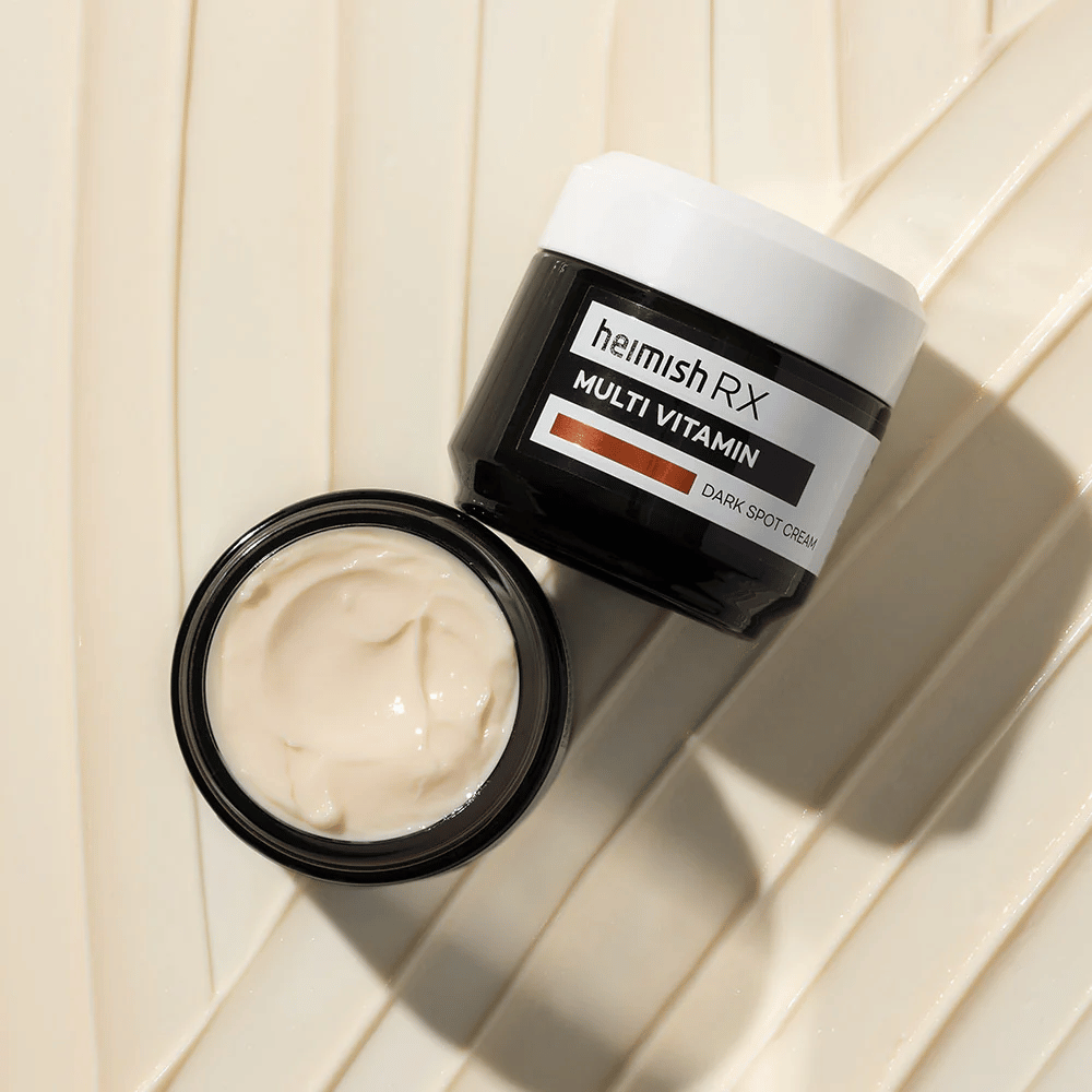 heimish RX Multi Vitamin Dark Spot Cream – um creme facial nutritivo para reduzir manchas escuras e dar à pele um tom mais uniforme. A textura suave do creme é exibida em um frasco aberto com embalagem elegante.