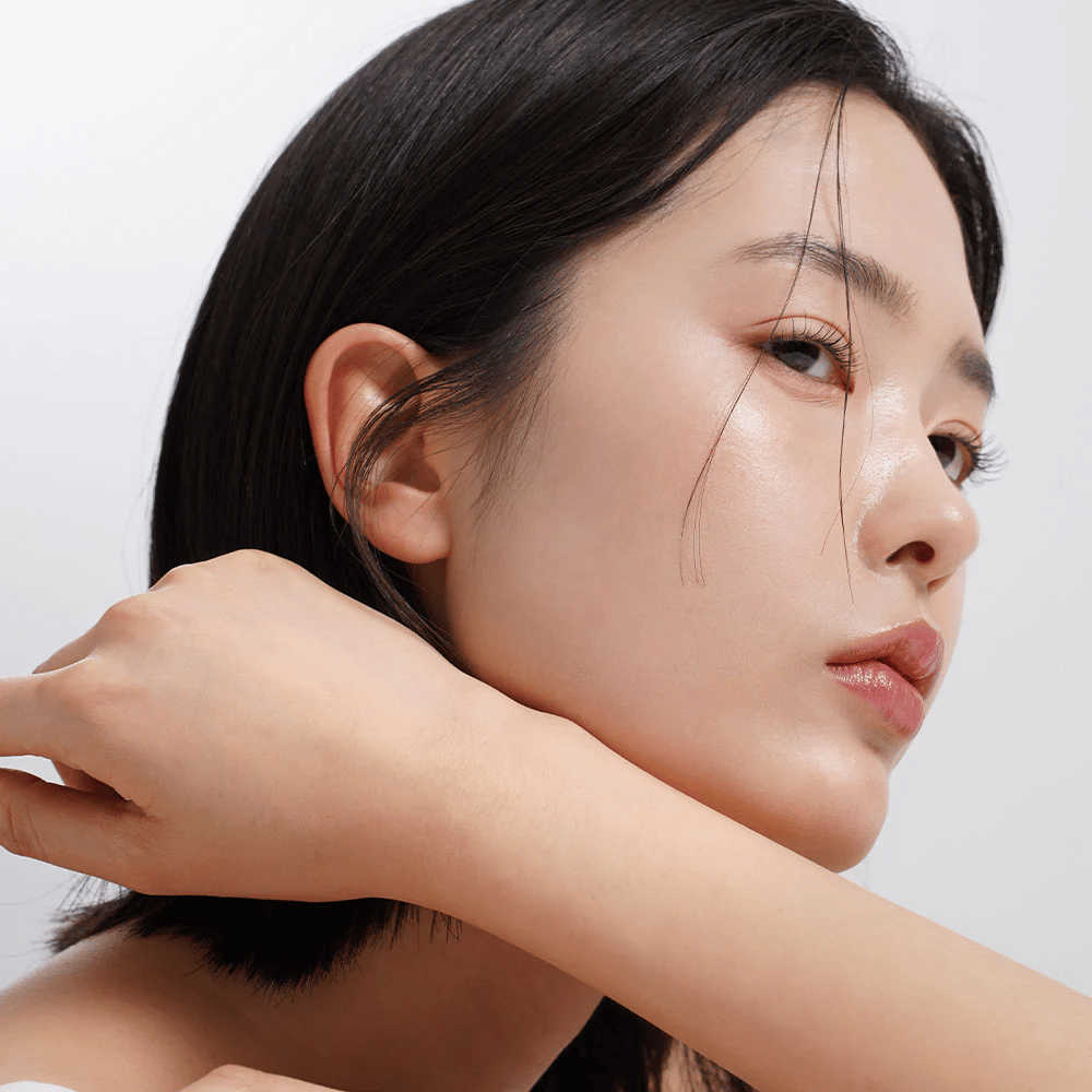 Close-up de uma mulher com pele uniforme, radiante e brilho natural. Inspiração perfeita para cuidados com a pele para uma pele saudável e hidratada.