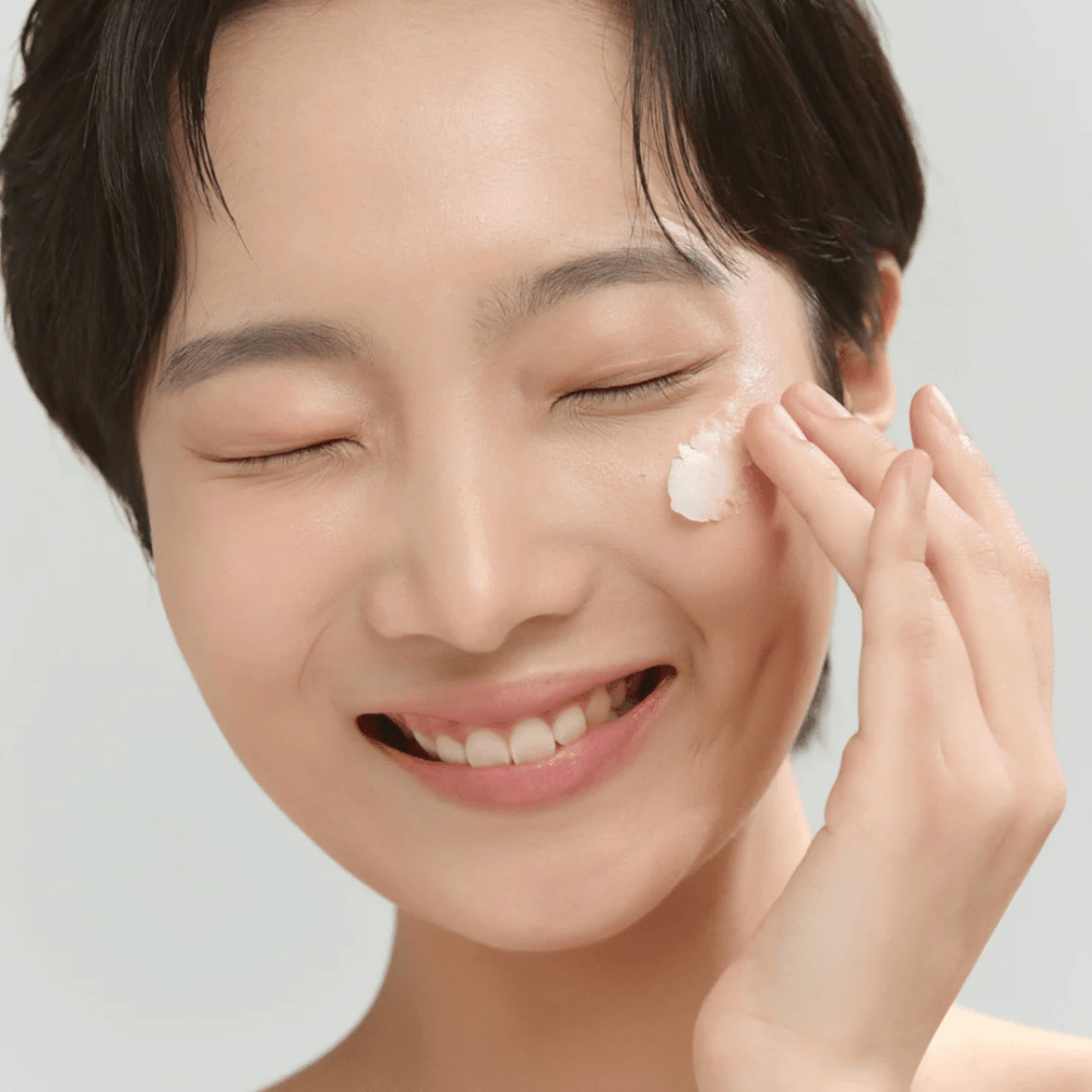 Modelo com pele luminosa aplicando Beauty of Joseon Radiance Cleansing Balm – bálsamo de limpeza coreano que dissolve maquiagem e impurezas.