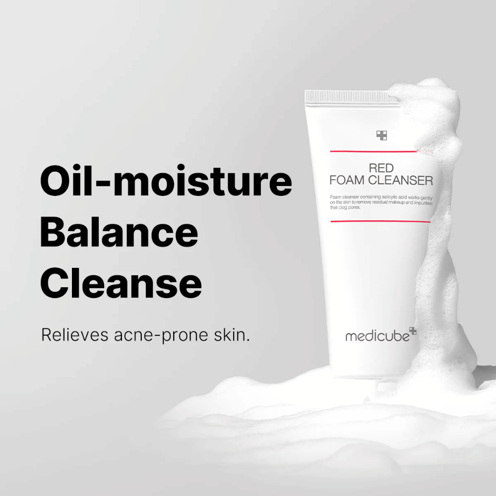 Tubo de Medicube Red Foam Cleanser em pé entre espuma espumante. O texto "Oil-moisture Balance Cleanse" é exibido à esquerda, com a descrição "Alivia a pele propensa a acne" abaixo. O fundo é cinza claro.
