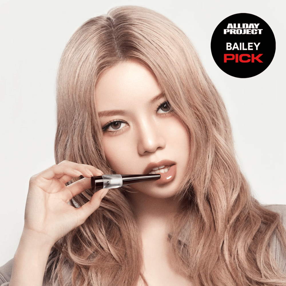 Modelo aplica VT Reedle Shot Lip Plumper Expert nos lábios, acabamento brilhante e lábios mais volumosos, marcado como Escolha de Bailey do All Day Project.