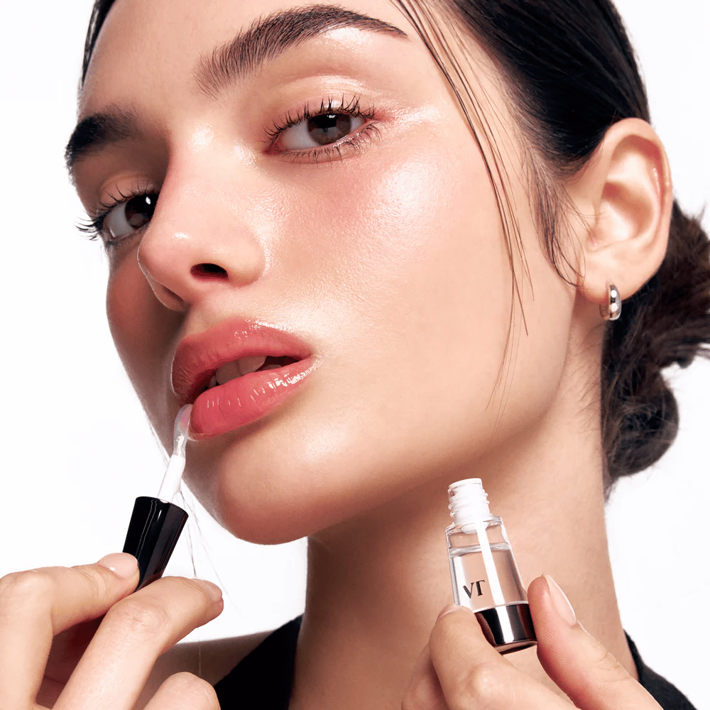Modelo aplica VT Cosmetics Reedle Shot Lip Plumper Beginner nos lábios para um aumento natural, brilho e hidratação com leve efeito de formigamento.
