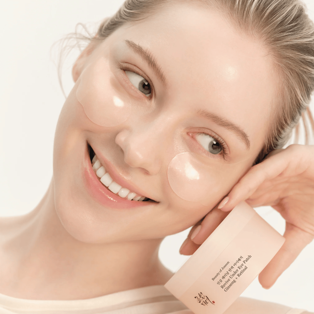 Modelo com Beauty of Joseon under eye patches e produto na mão, patches de olhos com ginseng e retinal para uma área dos olhos mais desperta e suave.