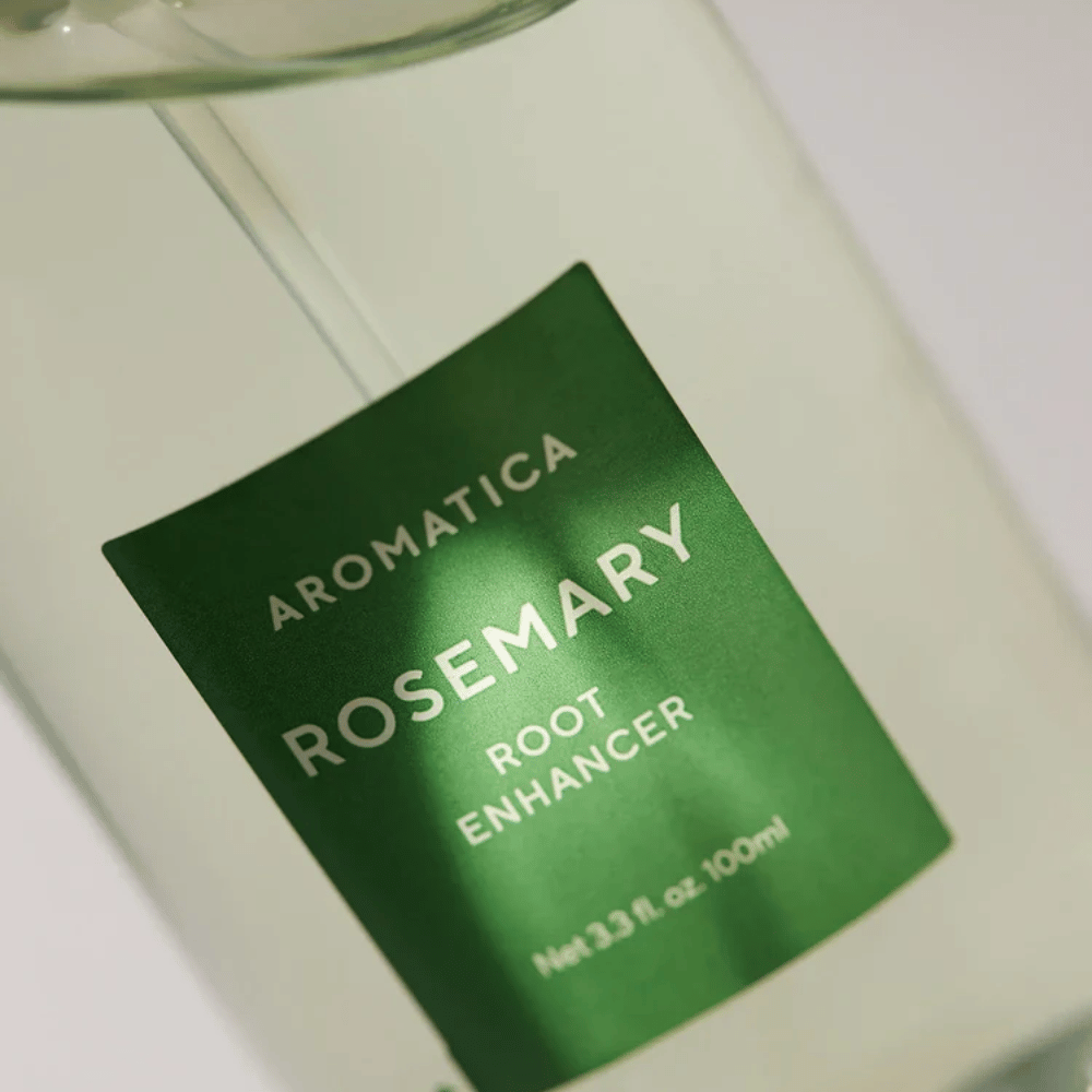 Imagem de detalhe do rótulo de AROMATICA Rosemary Root Enhancer. O rótulo verde e o frasco transparente destacam o aspeto limpo e minimalista do produto.
