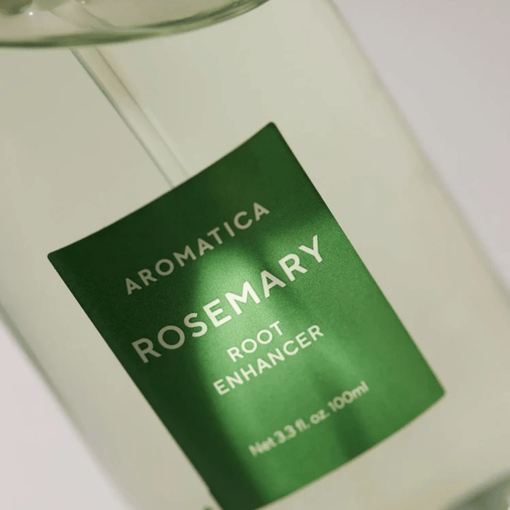 Imagem de detalhe do rótulo de AROMATICA Rosemary Root Enhancer. O rótulo verde e o frasco transparente destacam o aspeto limpo e minimalista do produto.