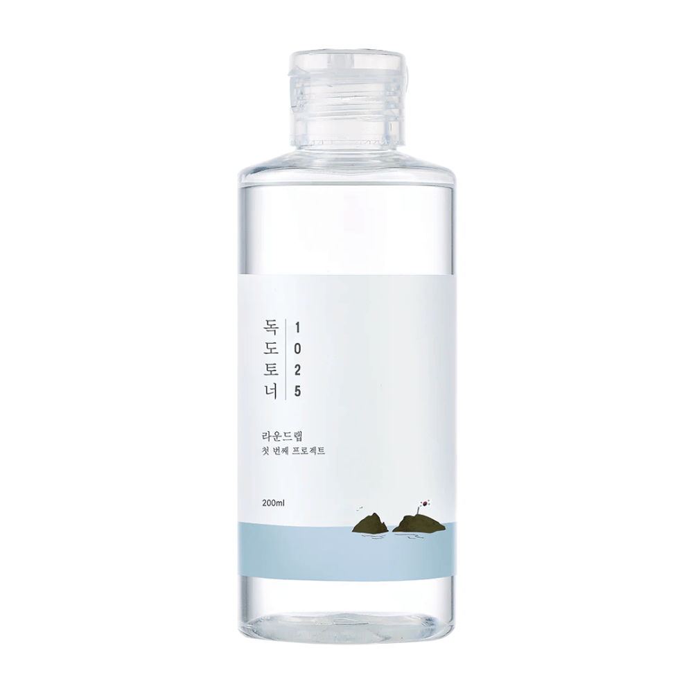 Uma garrafa aberta Round Lab 1025 Dokdo Toner com design simples e tema marítimo, sobre fundo branco.