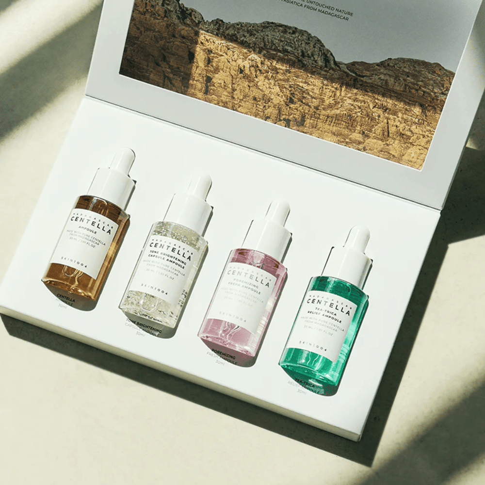 Uma caixa que contém Madagascar Centella Ampoule Kit de SKIN1004, que contém três tipos diferentes de produtos de cuidados com a pele para hidratação e hidratação.
