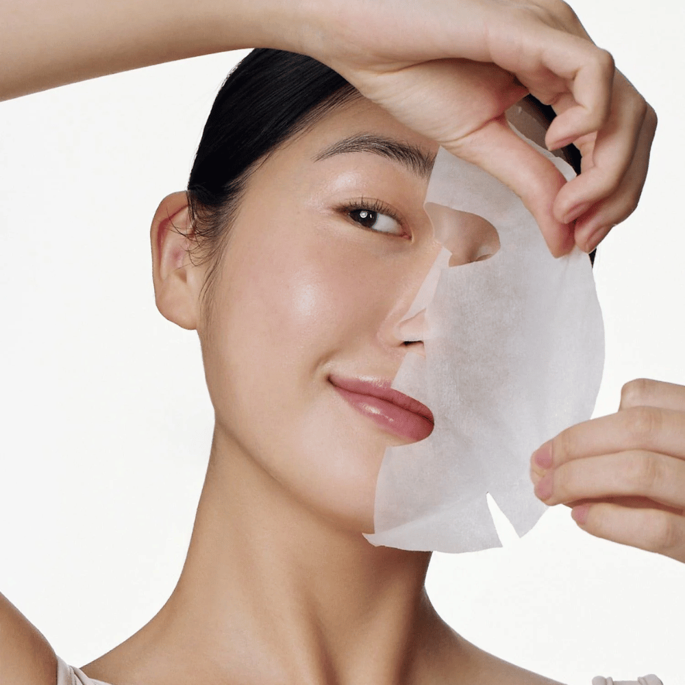 Esta imagem mostra uma pessoa a usar uma máscara facial, especificamente "Galactomyces Glutathione Daily Mask" de Some By Mi. A máscara ilumina a pele e dá um brilho radiante, ao mesmo tempo que cuida e hidrata profundamente a pele, graças a ingredientes como glutationa e vitamina C.